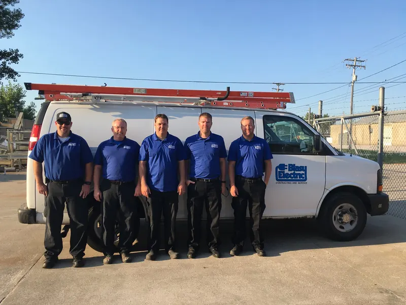 The Blasy Electric team in blue uniforms in front of a Blasy Electric service van