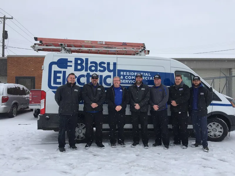 The Blasy Electric crew in winter jackets in front of a Blasy service van