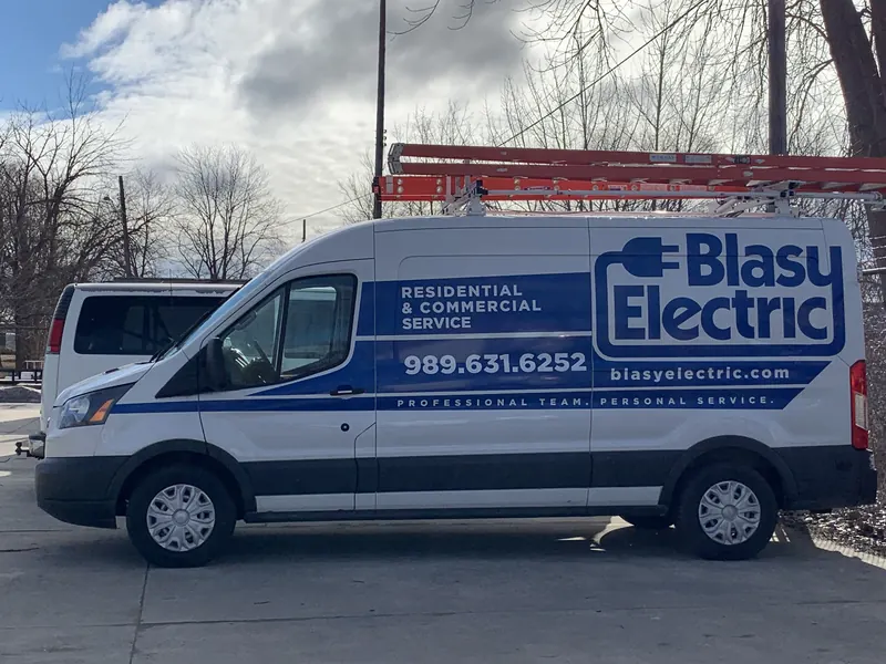 A white Blasy Electric service van lettered Residential and Commercial Service, 989.631.6252